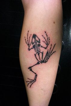 a tattoo on the leg of a person with a frog in it's body