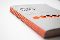 the design diary book is sitting on top of a white table with an orange dotted cover