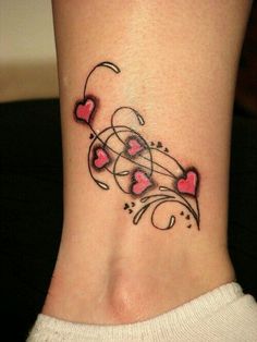 a woman's foot with hearts and swirls on the side, tattoo style