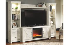 an entertainment center with a fireplace in the middle and shelves on either side, along with a chair