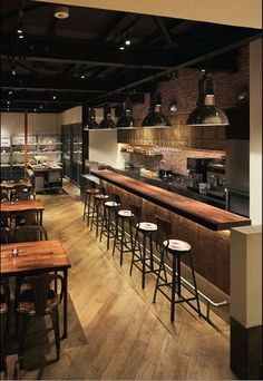 an empty restaurant with wooden tables and stools