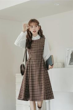 Round neck sleeveless plaid midi dress with thick shoulder straps in an all-over plaid print. Zips up at the back with a tie-waist and side pockets. Perfect for layering with your favorite blouse or sweater. S: 35" chest, 29" waist, 41.5" lengthM: 36.5" chest, 30.5" waist, 41.5" lengthL: 38" chest, 32" waist, 41.5" length Professor Clothes Women, Women Casual Dress Outfits, Turtle Neck With Dress Outfit, Plaid Pinafore Dress, How To Dress Preppy, Classy Teacher Outfits, Korean Dress Ideas, Fall Outfits Petite Women, 1920s Fashion Casual