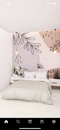 a white bed sitting in a bedroom next to a wall with black leaves on it