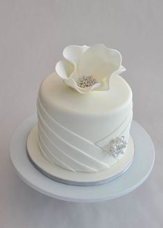 a white wedding cake with a flower on top