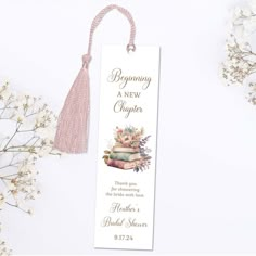 a bookmark with a tassel hanging from it's side next to flowers