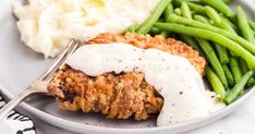 a plate with green beans, mashed potatoes and meatloaf