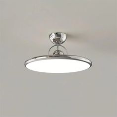 an overhead light fixture on the ceiling in a room with gray walls and flooring