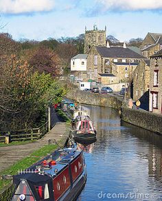 a narrow canal with boats on the side and buildings in the backgrouds