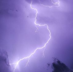 a purple sky with lightning and clouds in the background