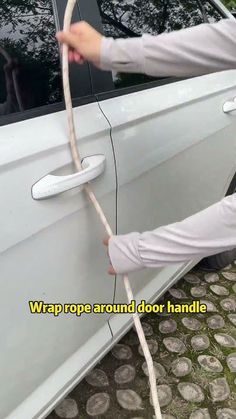 a man is holding onto the door handle of a car and pulling it out with his hands