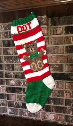 a christmas stocking hanging on a brick wall with a teddy bear in the bottom