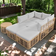 a wicker couch sitting on top of a wooden floor next to a lush green field