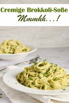 a white plate topped with pasta covered in pesto sauce and garnished with parsley