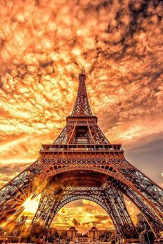 the eiffel tower in paris, france at sunset with colorful clouds above it