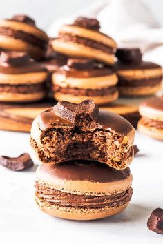 chocolate covered doughnuts stacked on top of each other with one bite taken out