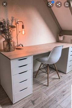 a desk with two chairs and a lamp on top of it in an attic room