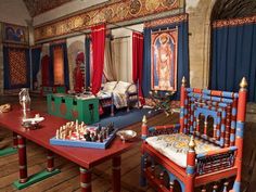 an elaborately decorated bedroom is shown with chess pieces on the table and in chairs