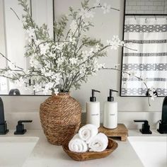 a bathroom with white flowers in a basket and soap dispensers on the counter