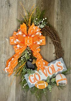 an orange and white wreath with the word go vol's on it next to some decorations