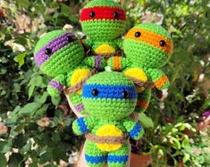 there is a crocheted stuffed toy with five different colored turtles on it's head