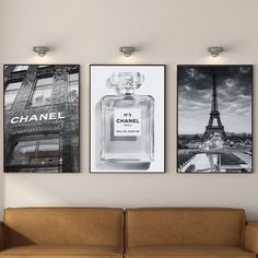 three chanel posters hang on the wall above a couch