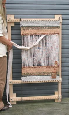 a woman standing next to a weaving machine