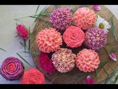 cupcakes decorated with pink and purple flowers on a plate