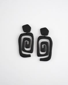 the black earrings are made from wood and have an abstract design on them, which is also