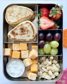 a bento box filled with fruit, crackers and other food items such as bread