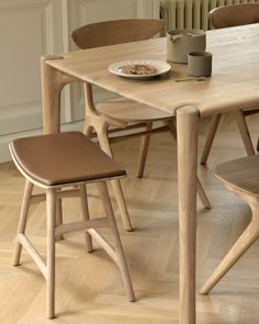 a wooden table with two chairs and a plate of food on it in front of a radiator