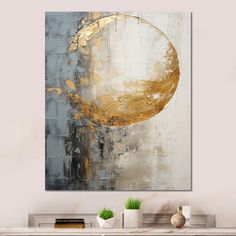 an abstract painting in gold and silver on a white wall