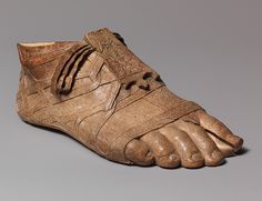 an old wooden shoe that has been carved to look like it is being worn by someone