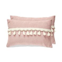 two pink pillows with tasselled trims on the sides and one in white