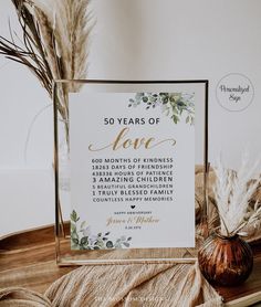 there is a sign that says 50 years of love on the table next to some feathers