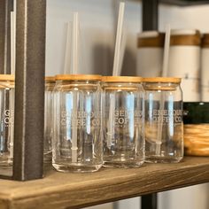 there are many glasses on the shelf with straws in each glass and one is empty