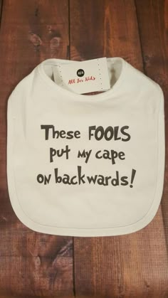 a bib that says, these fools put my cape on backwards's