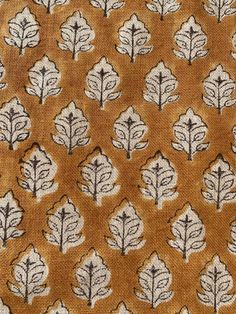 an orange and white fabric with black leaves on the side, in front of a brown background