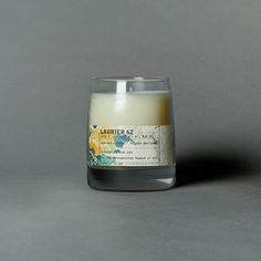 a candle that is sitting on a table in front of a gray background with the words laborer of god printed on it