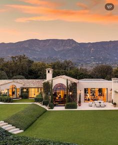 a large white house with mountains in the background