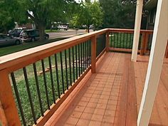 a wooden deck with black iron railings