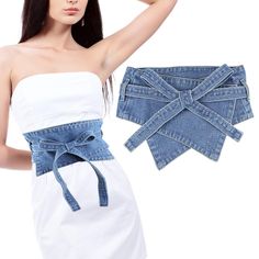 a woman wearing a white top and blue jean shorts with a bow tie around her waist