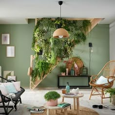 a living room filled with lots of plants on the wall next to a stair case