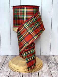 a red and green plaid ribbon on a wooden stand