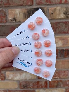 a person holding up some candy in front of a brick wall with the words angel wave of wine written on it