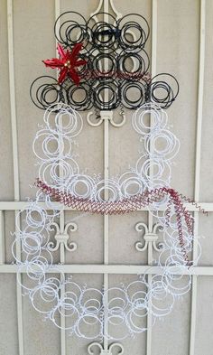 a metal wall hanging with circles and a red flower on it's side, in front of a white door