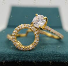 a close up of a diamond ring on top of a green cloth with an arrow