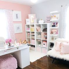 a pink and white room with lots of shelves, furniture and decor on the walls