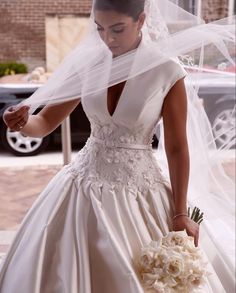 a woman in a wedding dress holding a bouquet