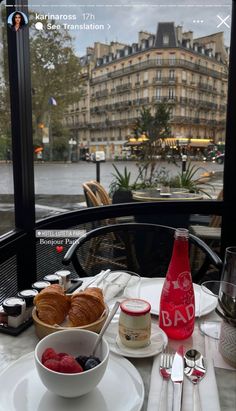 a table with food and drinks on it in front of a window