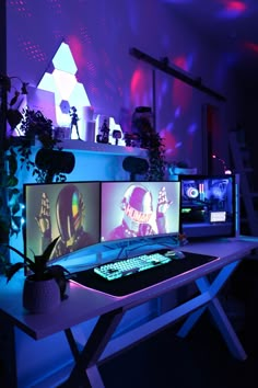 three computer monitors sitting on top of a desk in front of a purple wall and plant